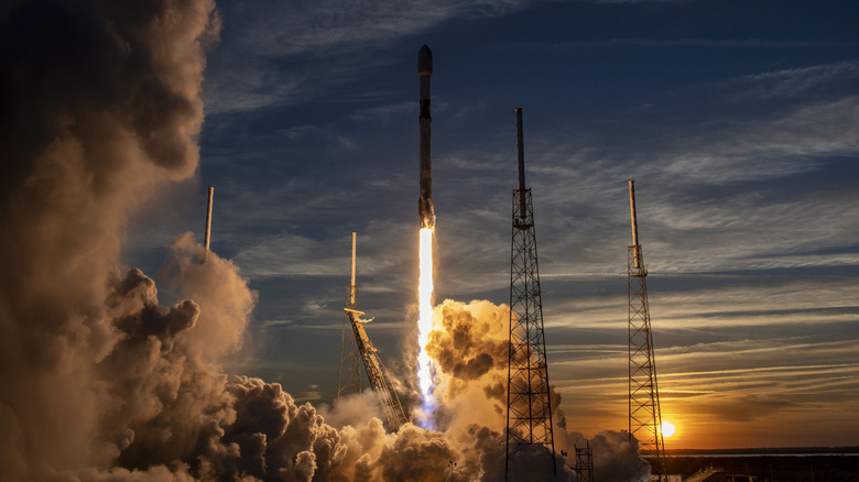 A SpaceX Falcon 9 rocket lifting off at sunset