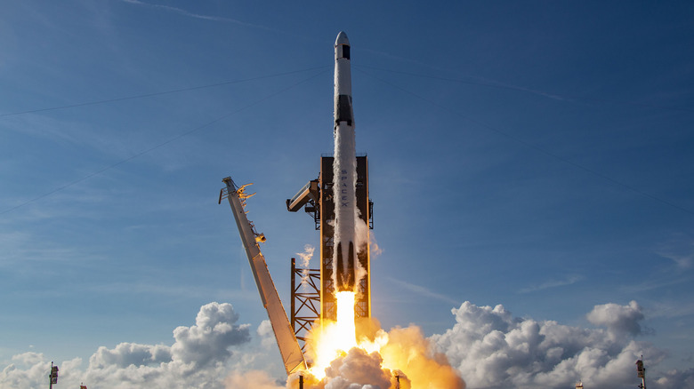 A SpaceX rocket lifting off with clear blue skies