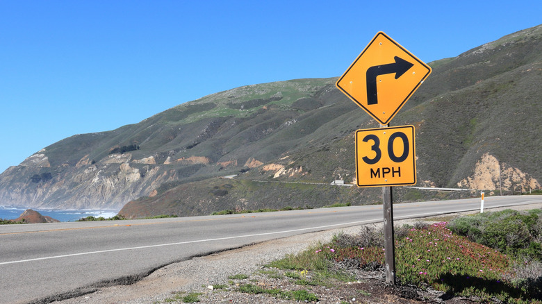 30 mph speed advisory sign for a sharp right curve on a beach highway