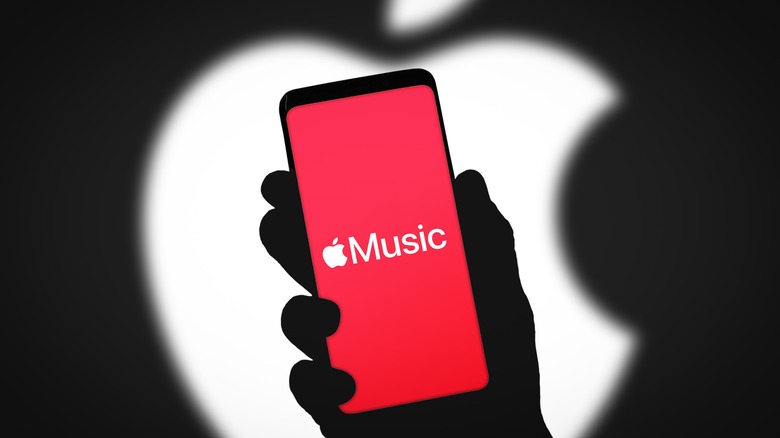 Apple Music logo displayed on smartphone display with blurred Apple logo in background