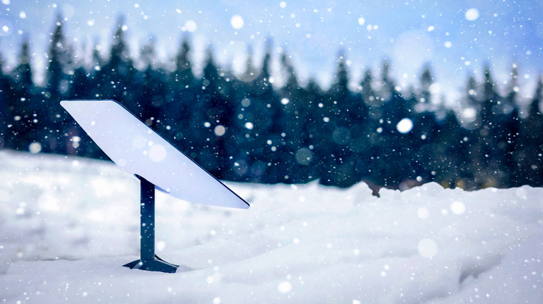 A Starlink internet dish enduring snowfall