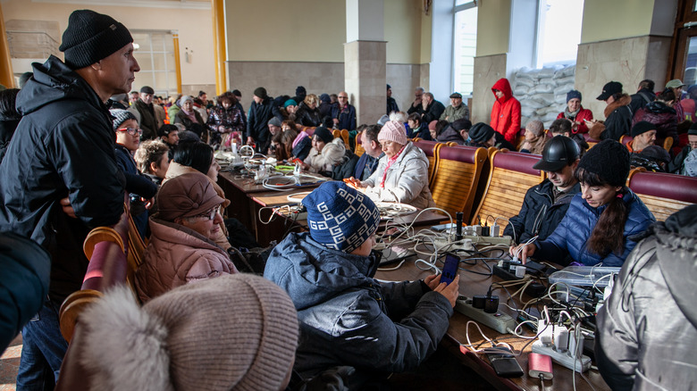 Ukrainians huddled around chargers