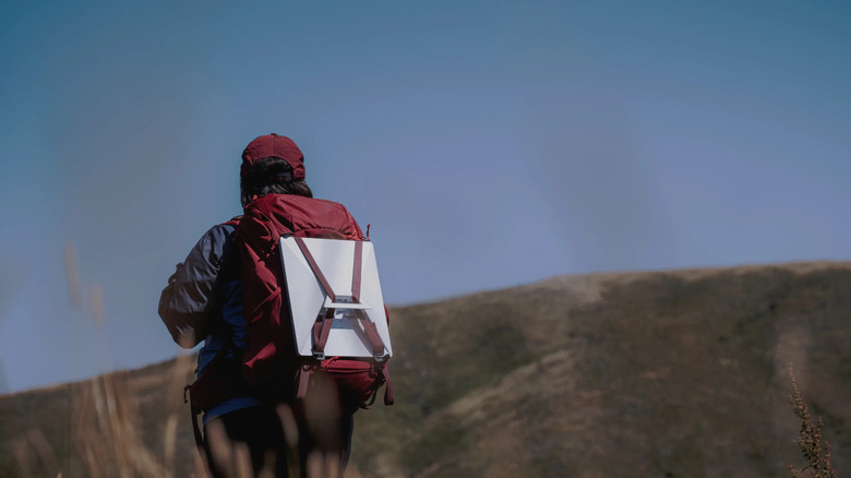 person backpacking with Starlink Mini
