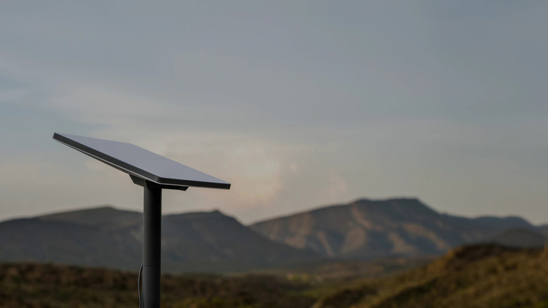 Starlink dish on pole with mountains in background