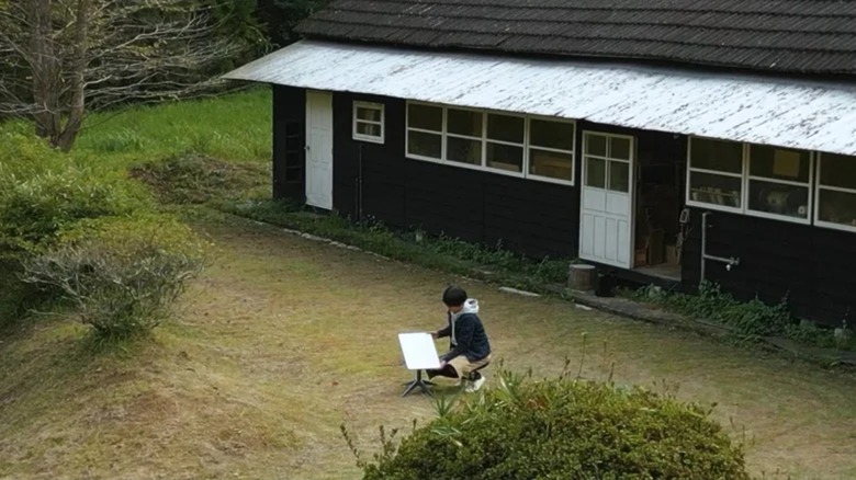 Person outside house fiddling with Starlink dish
