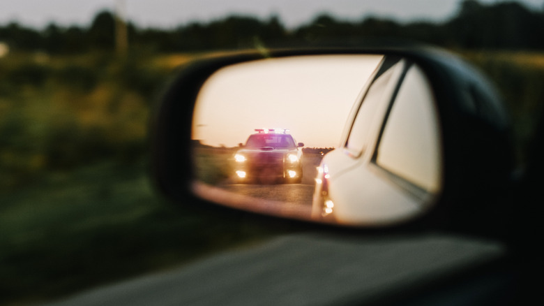 View of patrol car in rearview mirror