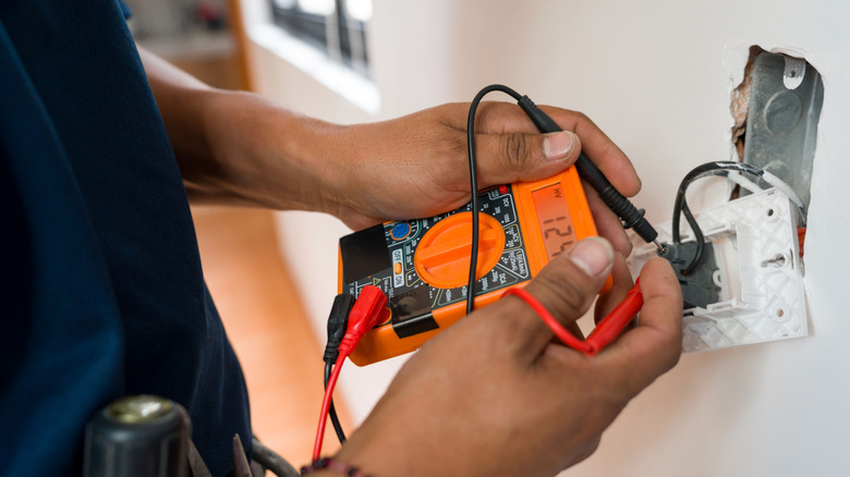 person conducting electrical work at an outlet