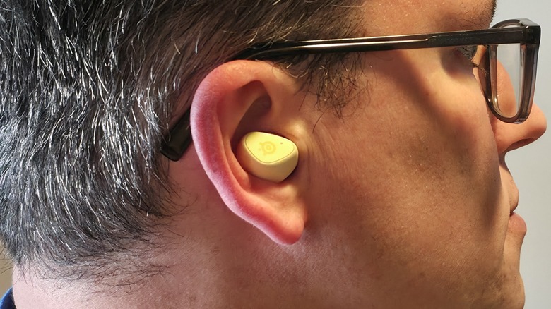 A man wearing an Arctis GameBud in his right ear