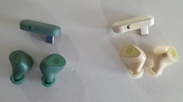 The Matcha and Yuzu SteelSeries Arctis GameBuds out of their cases with their dongle
