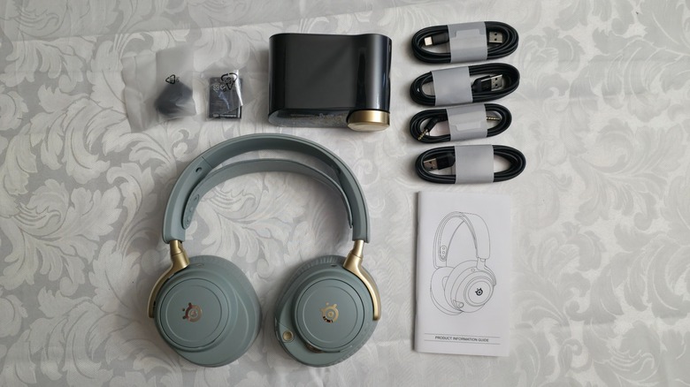 The full contents of the box for the Arctis Nova Elite laid out on a tablecloth