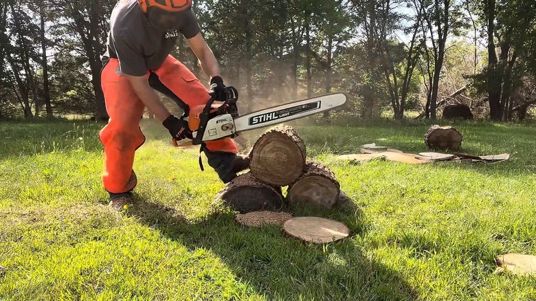 A man cutting lumber with a classic STIHL Farm Boss MS-290 chainsaw