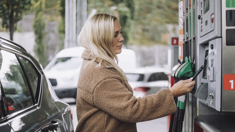 Woman paying for gas with her smartphone