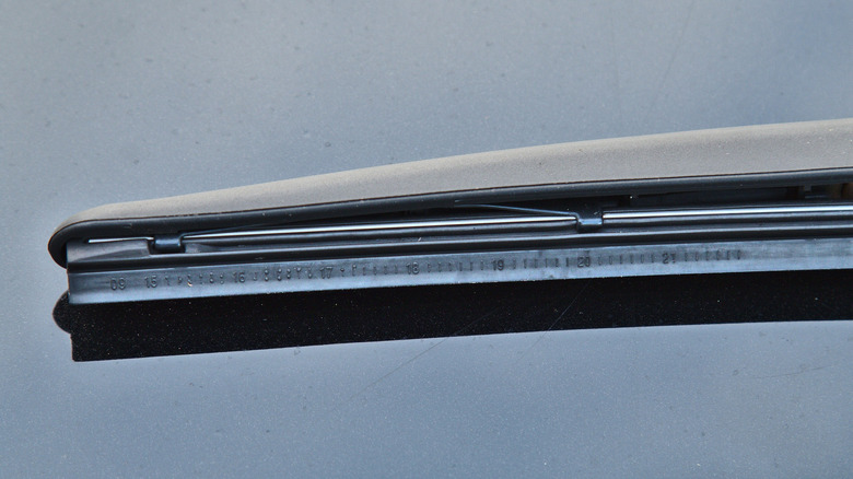 Windshield wiper blades on a car, small raised numbers visible.
