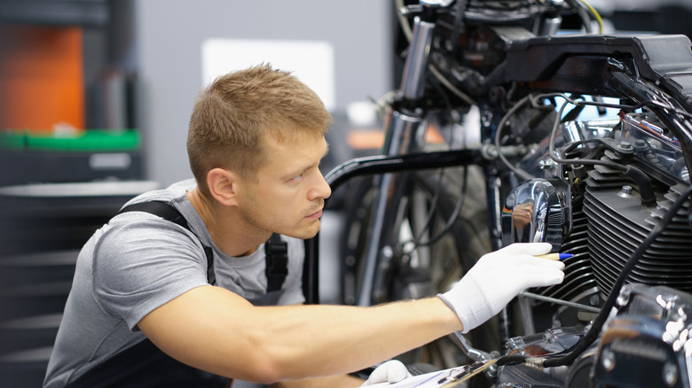 man repairing motorcycle