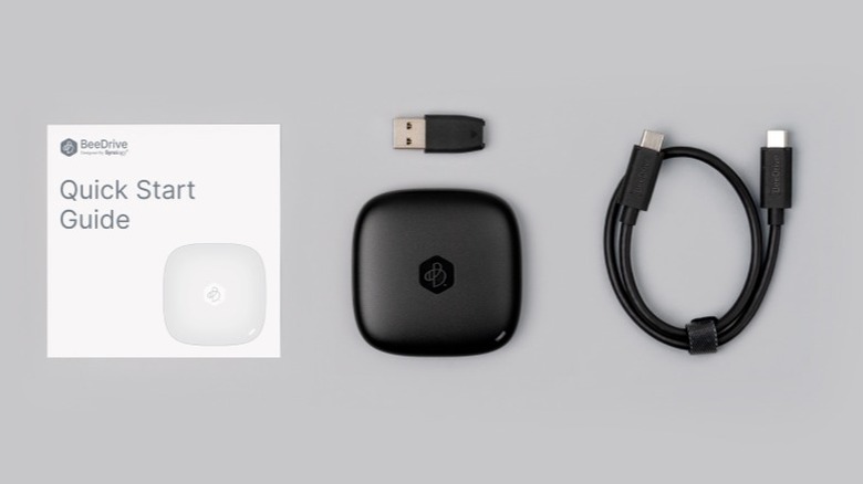 Synology BeeDrive and included accessories on a gray background