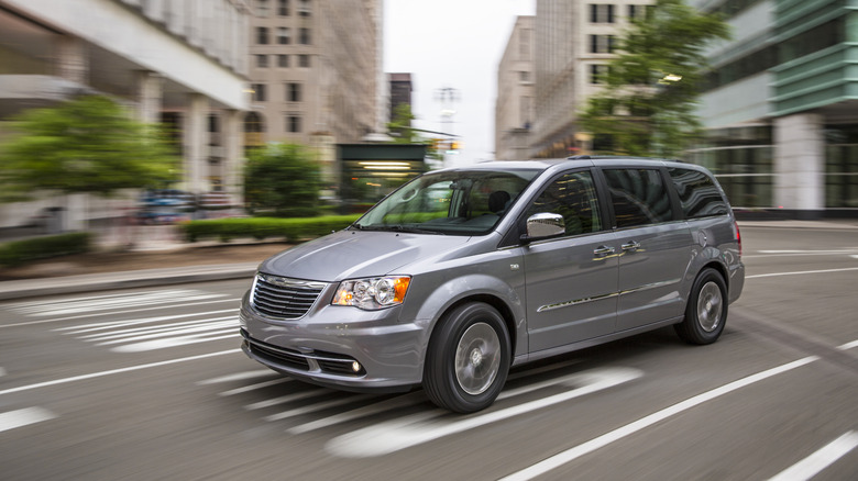 2014 Chrysler Town & Country minivan driving on urban road, front-left 3/4 view