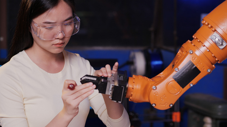 Woman working robot arm