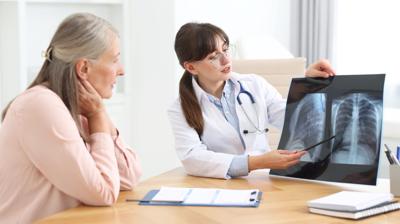 Doctor showing chest x-ray to patient on office computer