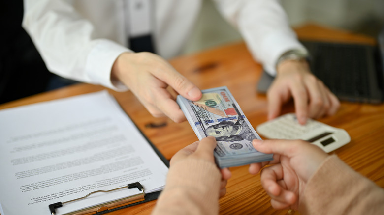 Cashier handing over cash in a bank