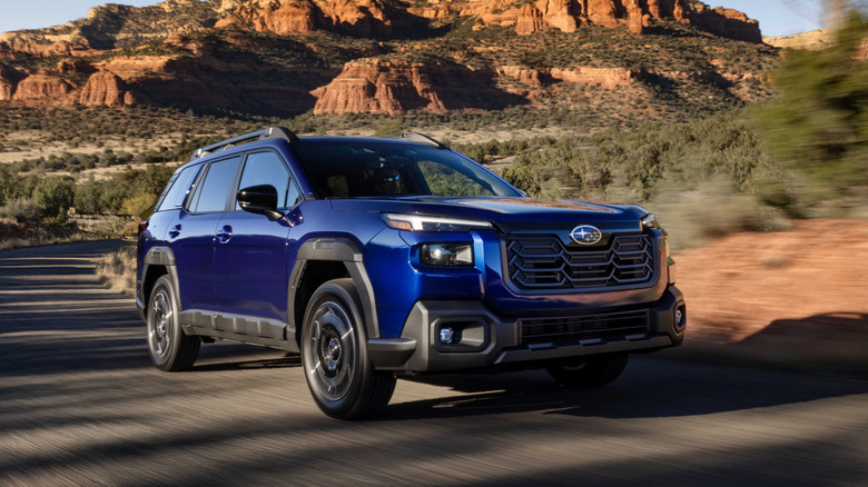 A bright blue 2026 Subaru Outback on a dessert road