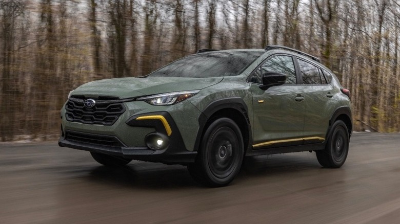 Subaru Crosstrek Sport driving on a road with trees in the background