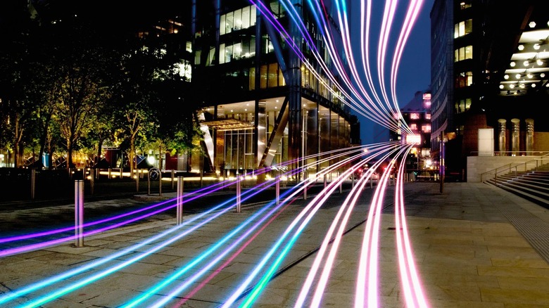 Depiction of a street at night overlaid with multi-colored lines