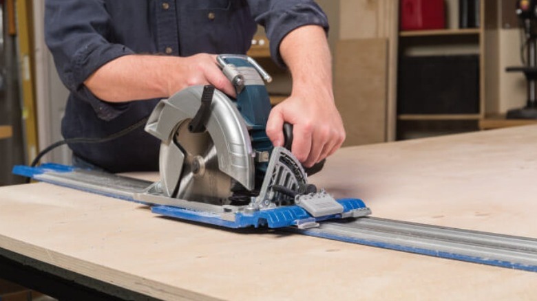 Carpenter using Kreg track saw on plywood