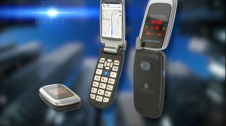 The Commodore Callback flip phone in the SX Silver colorway against a blurred blue cityscape