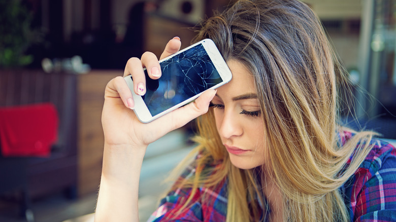 Woman disappointed with her broken, old smartphone