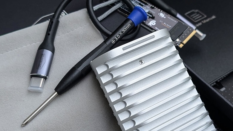 Screwdriver and USB-C cord with SSD and enclosure.