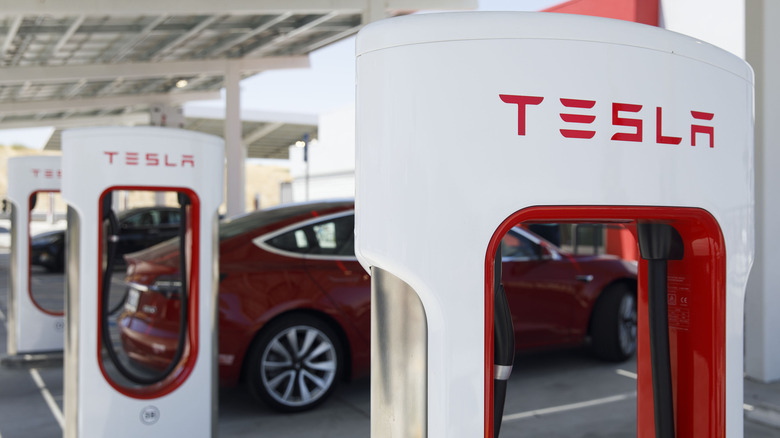 red tesla at a tesla charging station