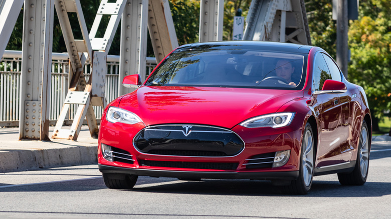 red model S driving over bridge