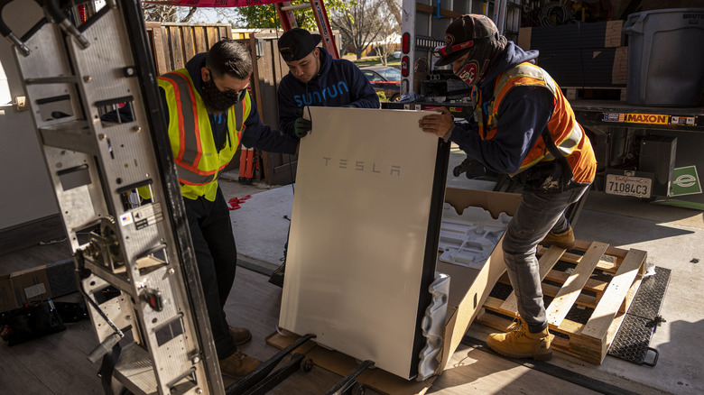 Instaladores instalando um Tesla Powerwall