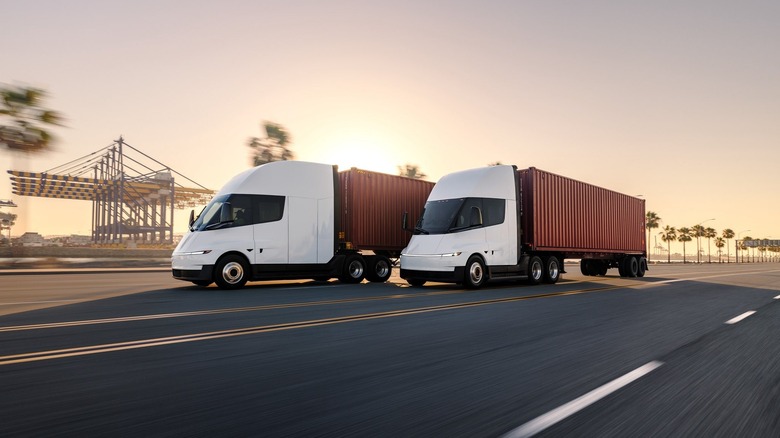 two tesla semi trucks on the road