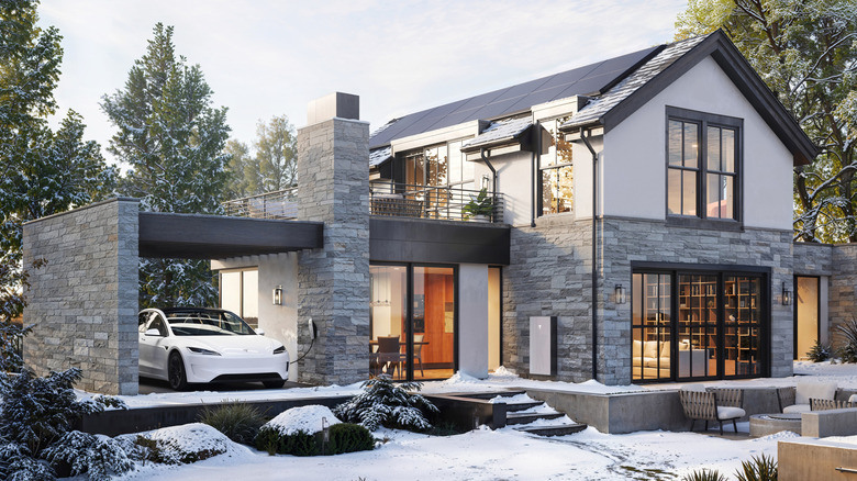Tesla virtual power plant home in snow showing Tesla solar panels, a Tesla Powerwall, and a Tesla EV