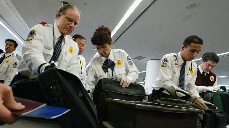 TSA agents inspecting bags in the airport
