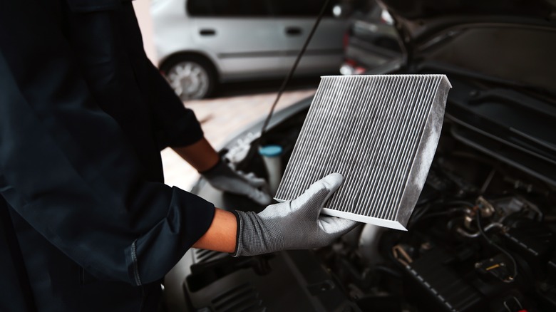 Mechanic holding a dirty air filter