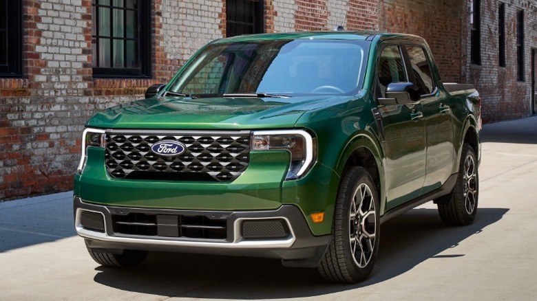 Green Ford Maverick parked in front of a brick building