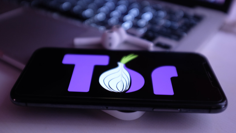 O logotipo do Tor em um telefone, em um laptop