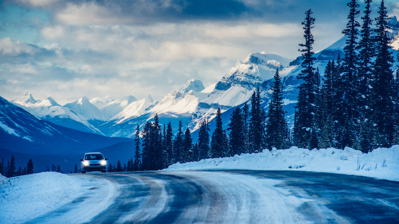 Car driving down snowy road