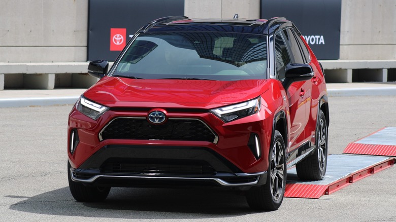 Red Toyota RAV4 Prime outside Toyota dealership