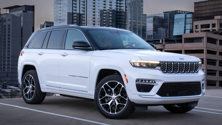White Jeep Grand Cherokee 4xe parked with high-rise buildings in the background