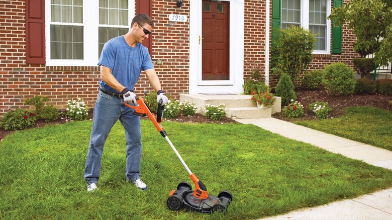 Landscaper mowing a small lawn with Black+Decker mower