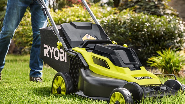 Landscaper cutting a lawn with Ryobi mower