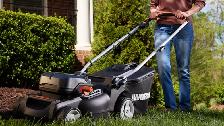 Landscaper mowing lawn with Worx mower