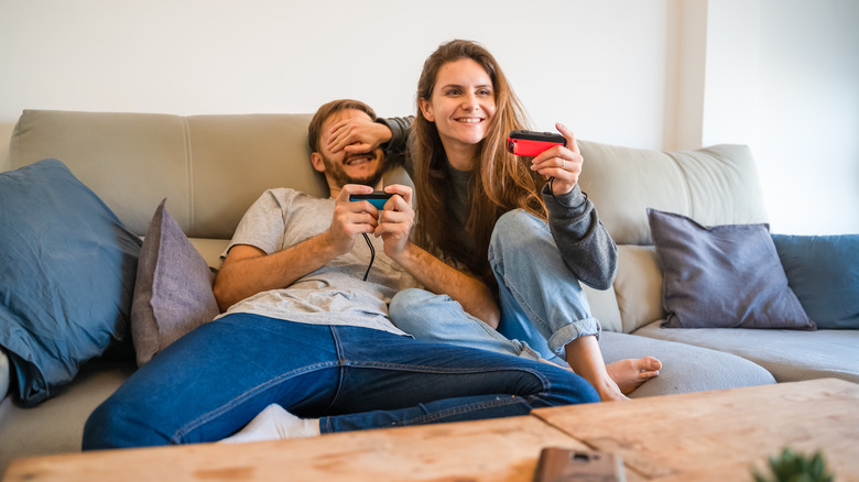 A couple playing the switch on a couch