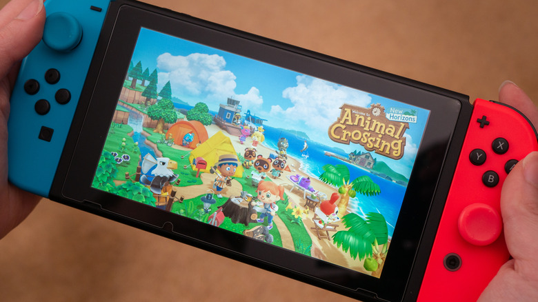A Nintendo Switch with Animal Crossing loading on screen