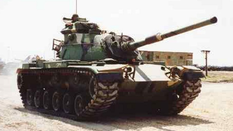 An M60 Patton Main Battle Tank driving on dirt path