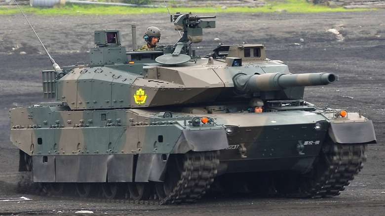 A JGSDF Type 10 Tank in 2010 with the tank commander's head peeking out of the hatch alongside the driver