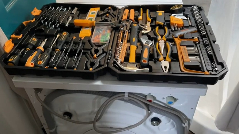 open Dekopro tool case with black and yellow tools on top of a washing machine